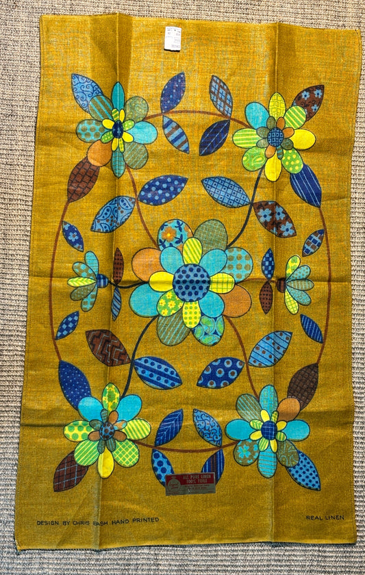 Decorative fabric panel with colorful floral design on a mustard yellow background