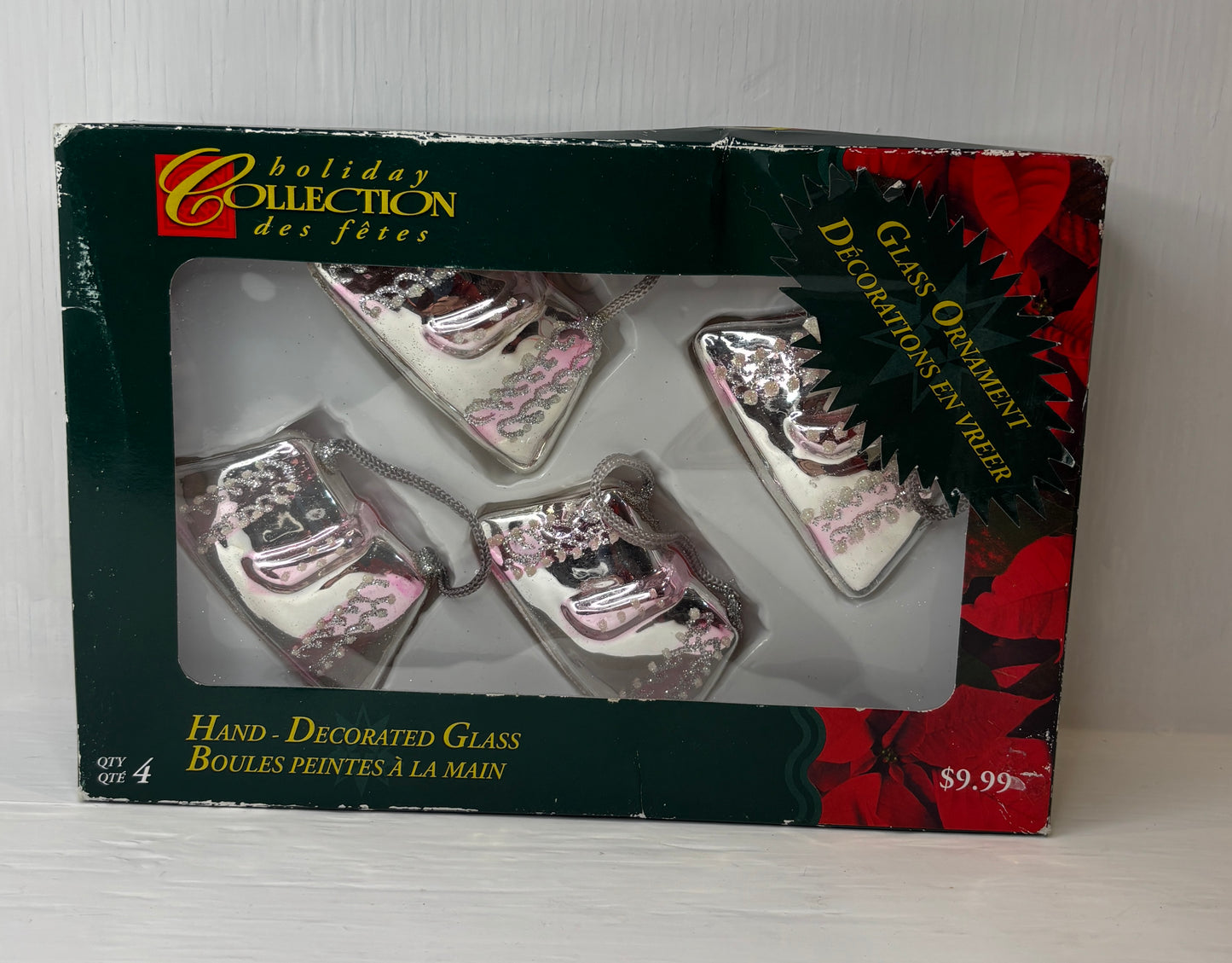 Box of hand-decorated glass Christmas ornaments with 'Holiday Collection' branding.