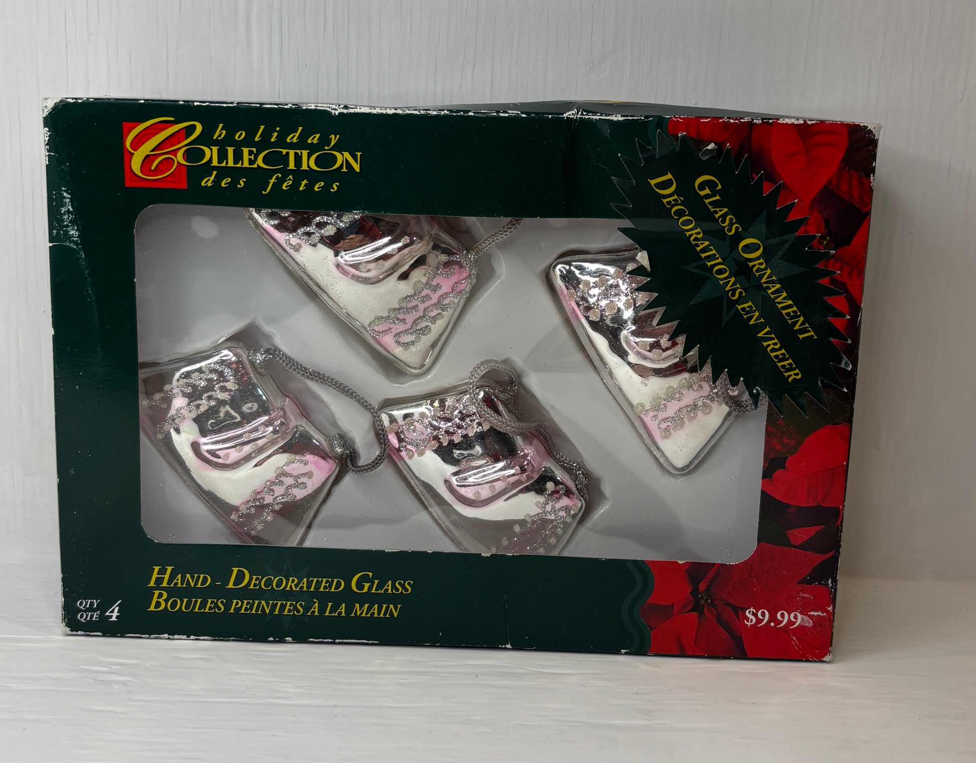 Box of hand-decorated glass Christmas ornaments with 'Holiday Collection' branding.