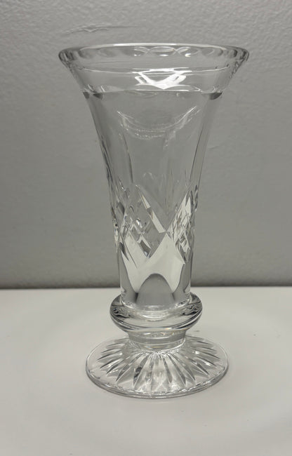 Clear glass vase with etched design on a white surface and gray background