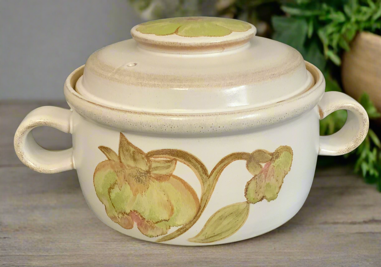 a casserole pot with green flowers, leaves and lid