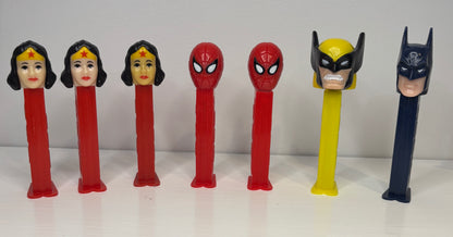 Superhero-themed PEZ dispensers on a white background