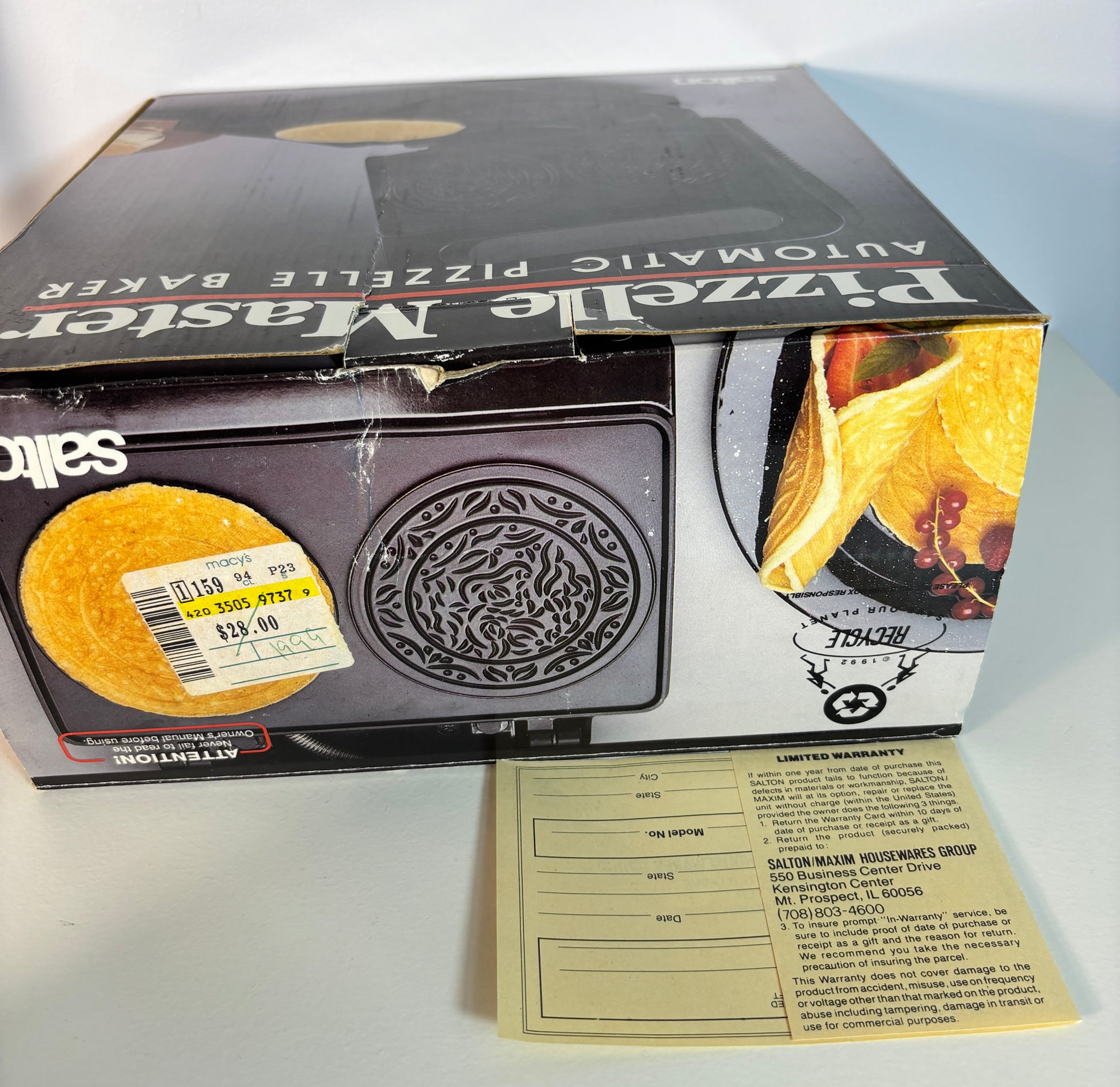 Saltz Pizzelle Master automatic pizzelle baker box shown with a price sticker on the front and a limited warranty card in front, on a white surface.