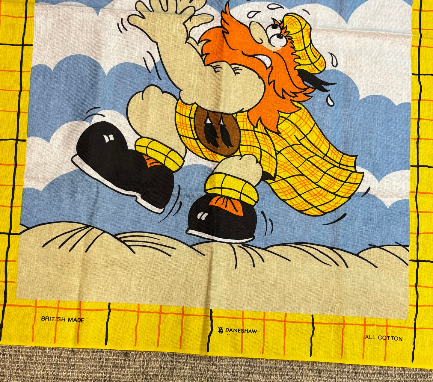 Cartoon character in a yellow raincoat on a fabric background with 'British Made' and 'Danebrow' branding.