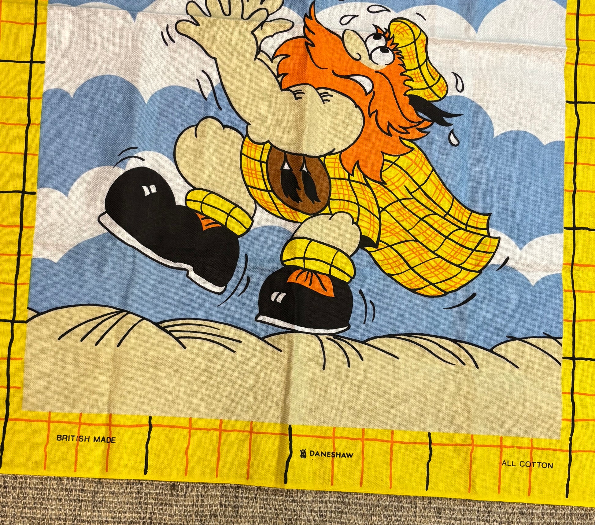 Cartoon character in a yellow raincoat on a fabric background with 'British Made' and 'Danebrow' branding.