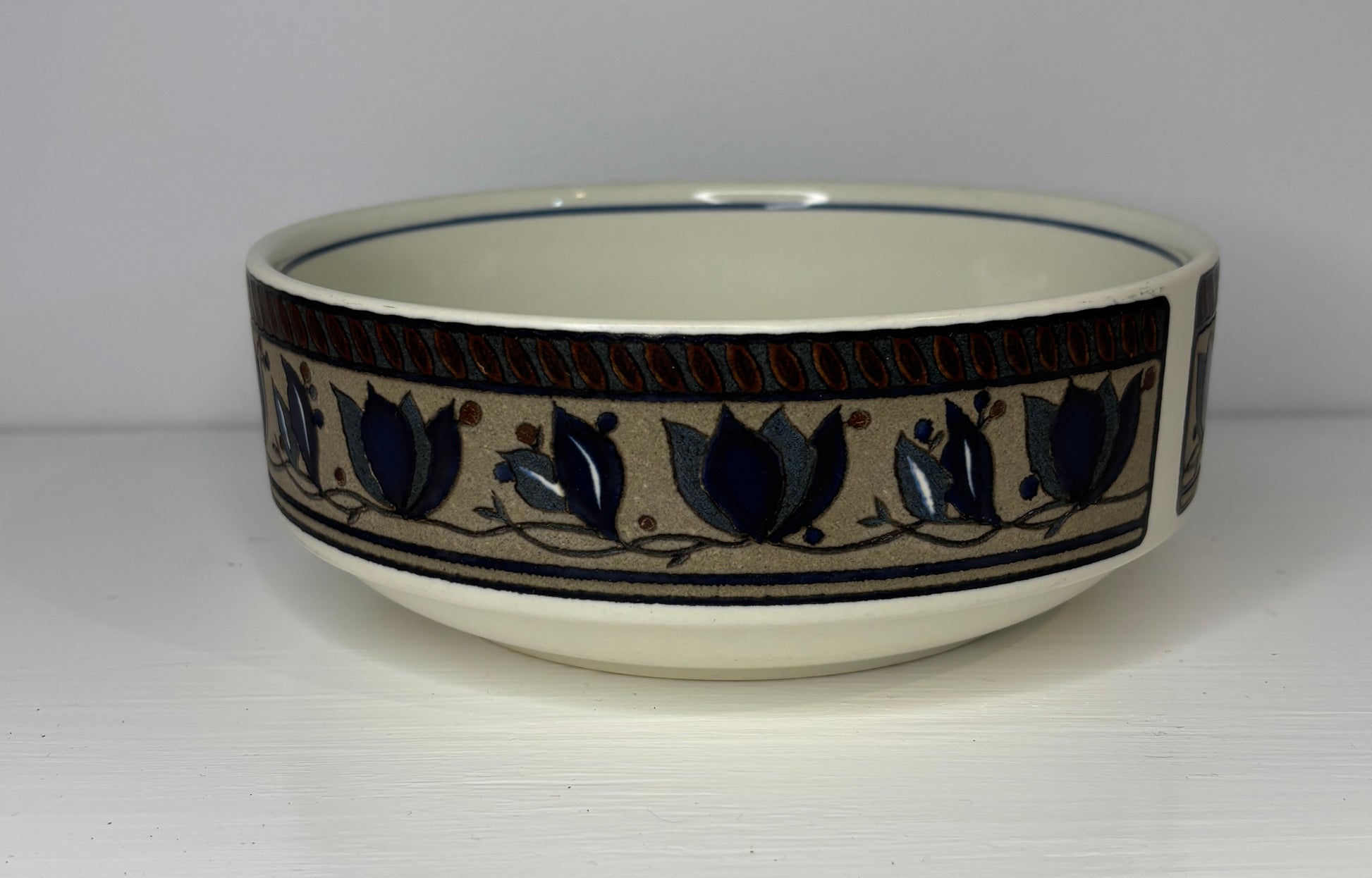 Ceramic bowl with decorative blue tulip pattern on a white background