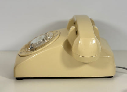 Beige rotary phone on a white background