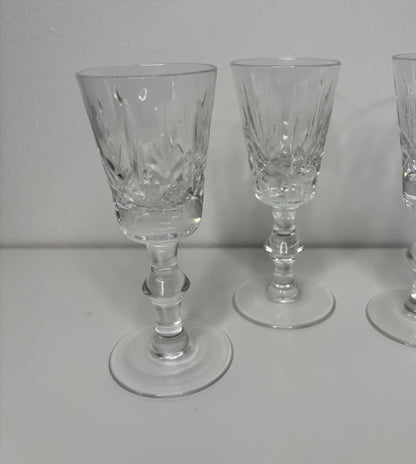 Set of three clear glass goblets on a white surface with a plain background