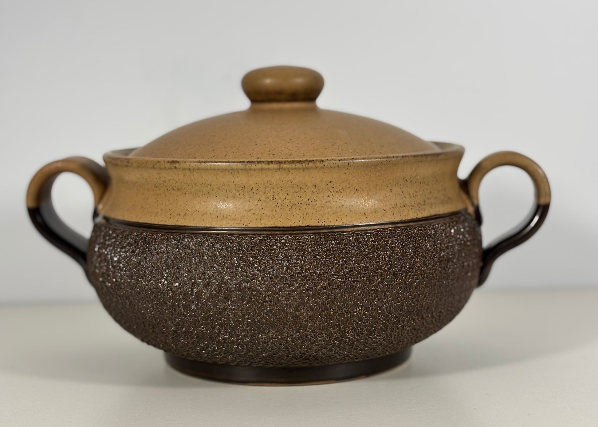 Brown ceramic pot with a textured surface on a white background