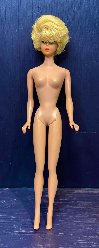 barbie doll with blonde hair against a blue background