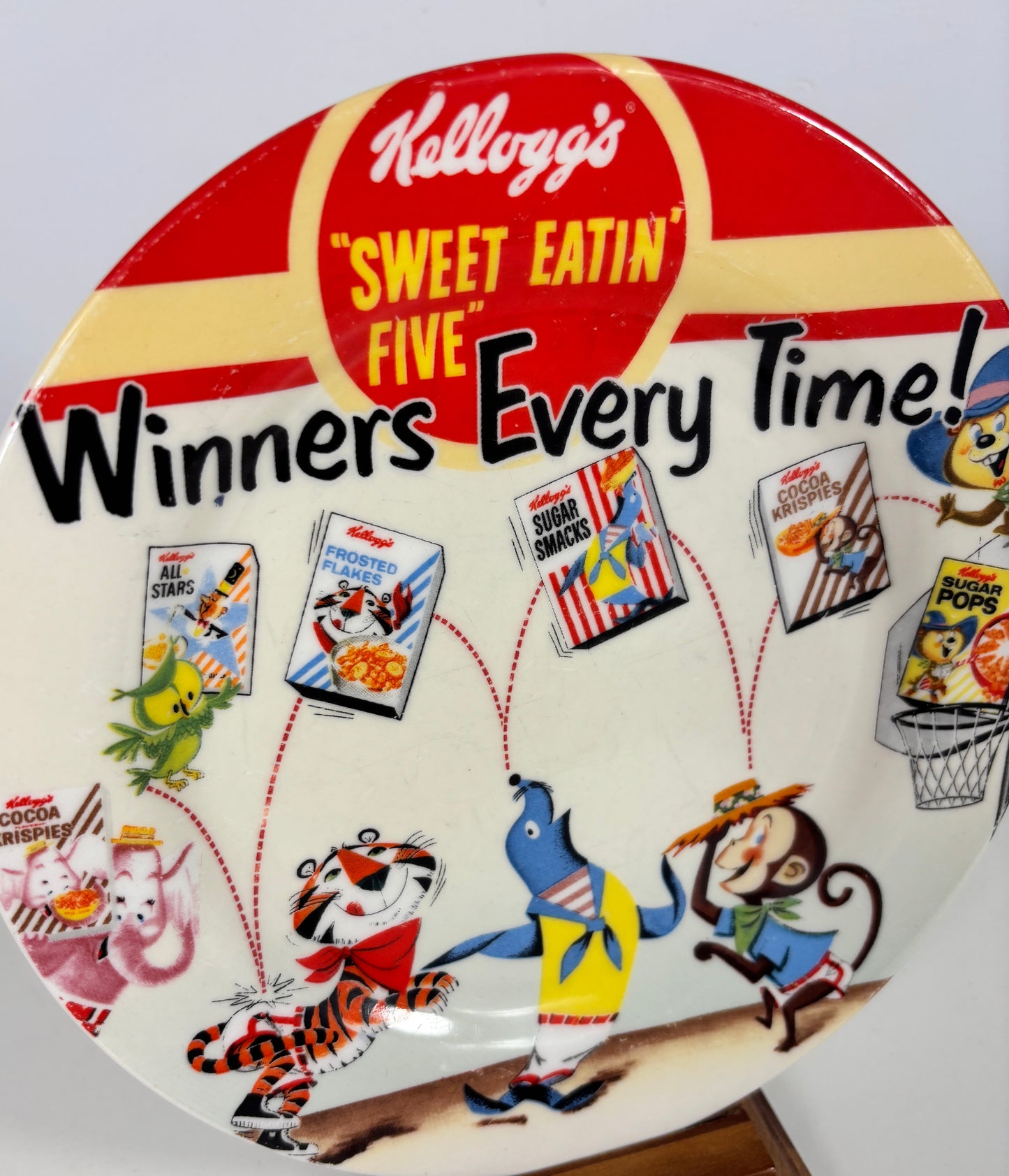 Kellogg's promotional plate with cartoon characters and cereal boxes on a white background