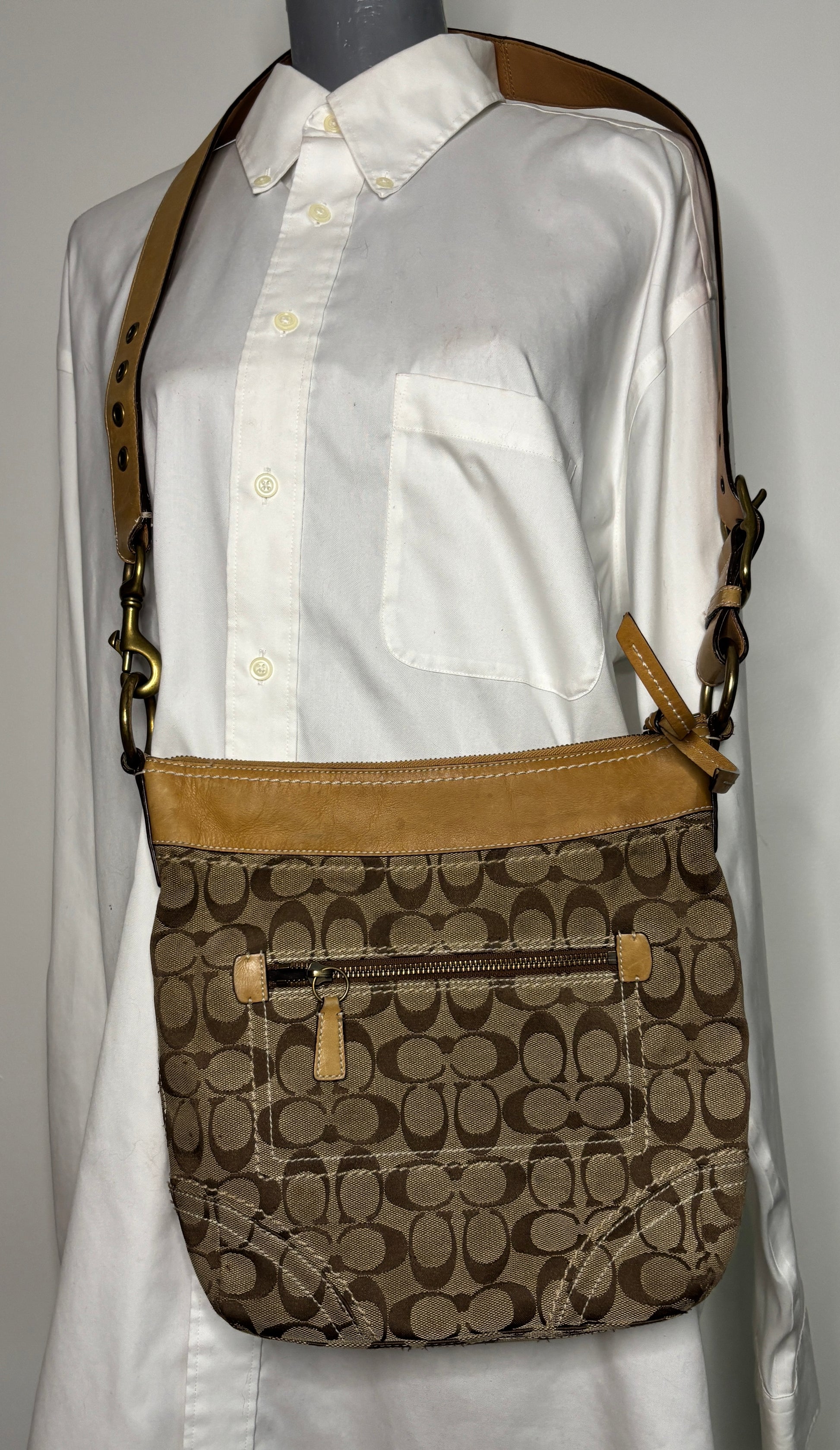 Coach crossbody bag with brown and beige pattern on a mannequin wearing a white shirt.