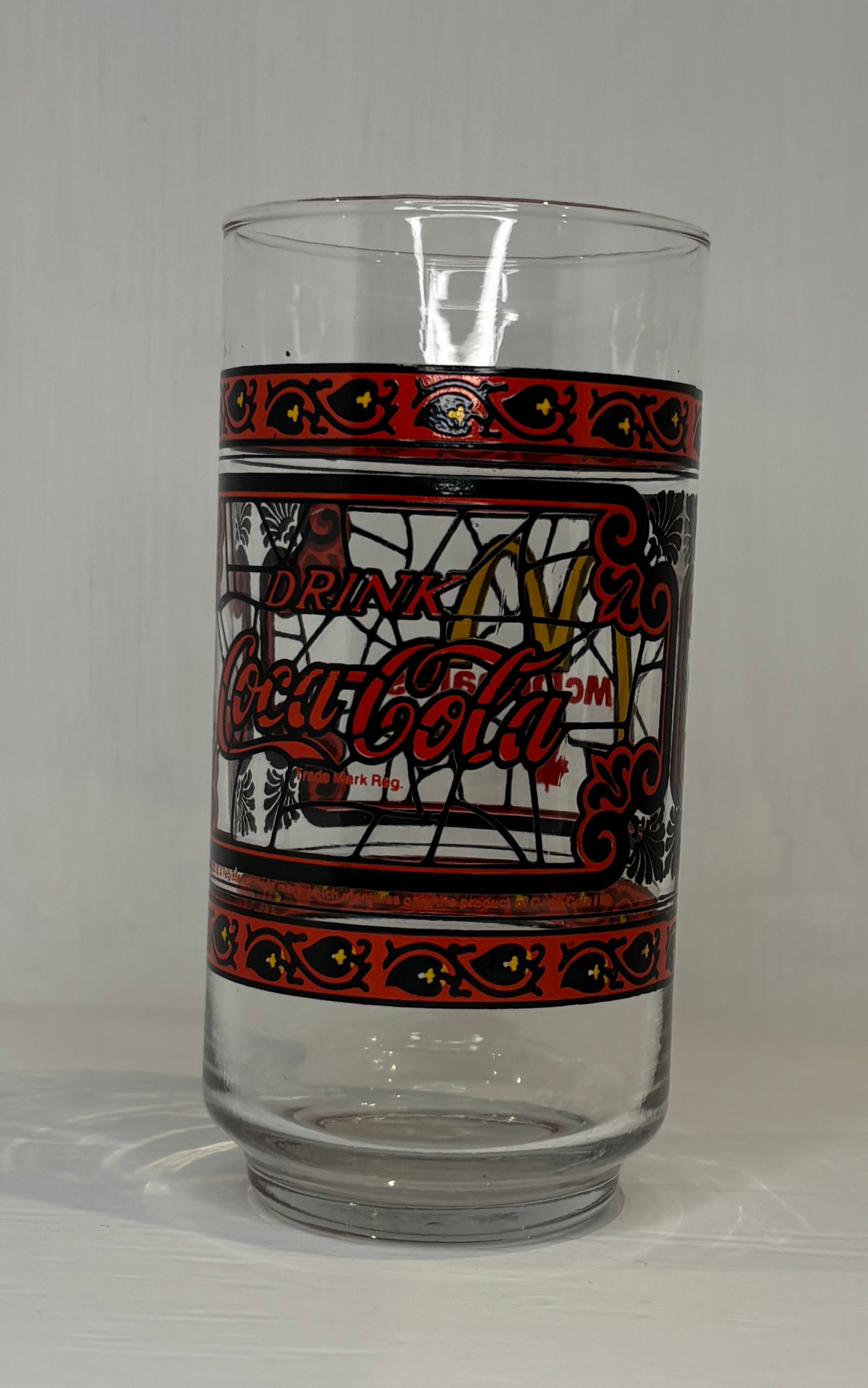 Coca-Cola glass with decorative band on a gray background