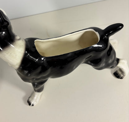 Black and white ceramic dog-shaped planter on a plain background