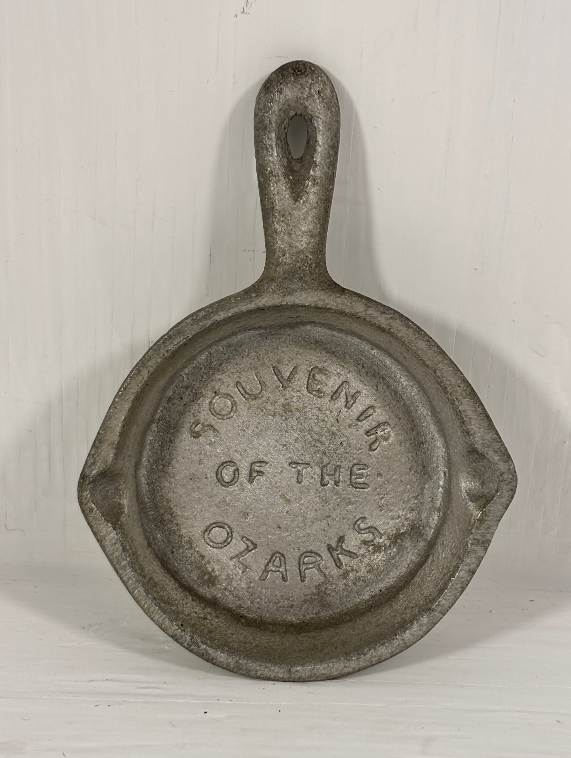 Small cast iron skillet with 'Souvenir of the Ozarks' text on a white background