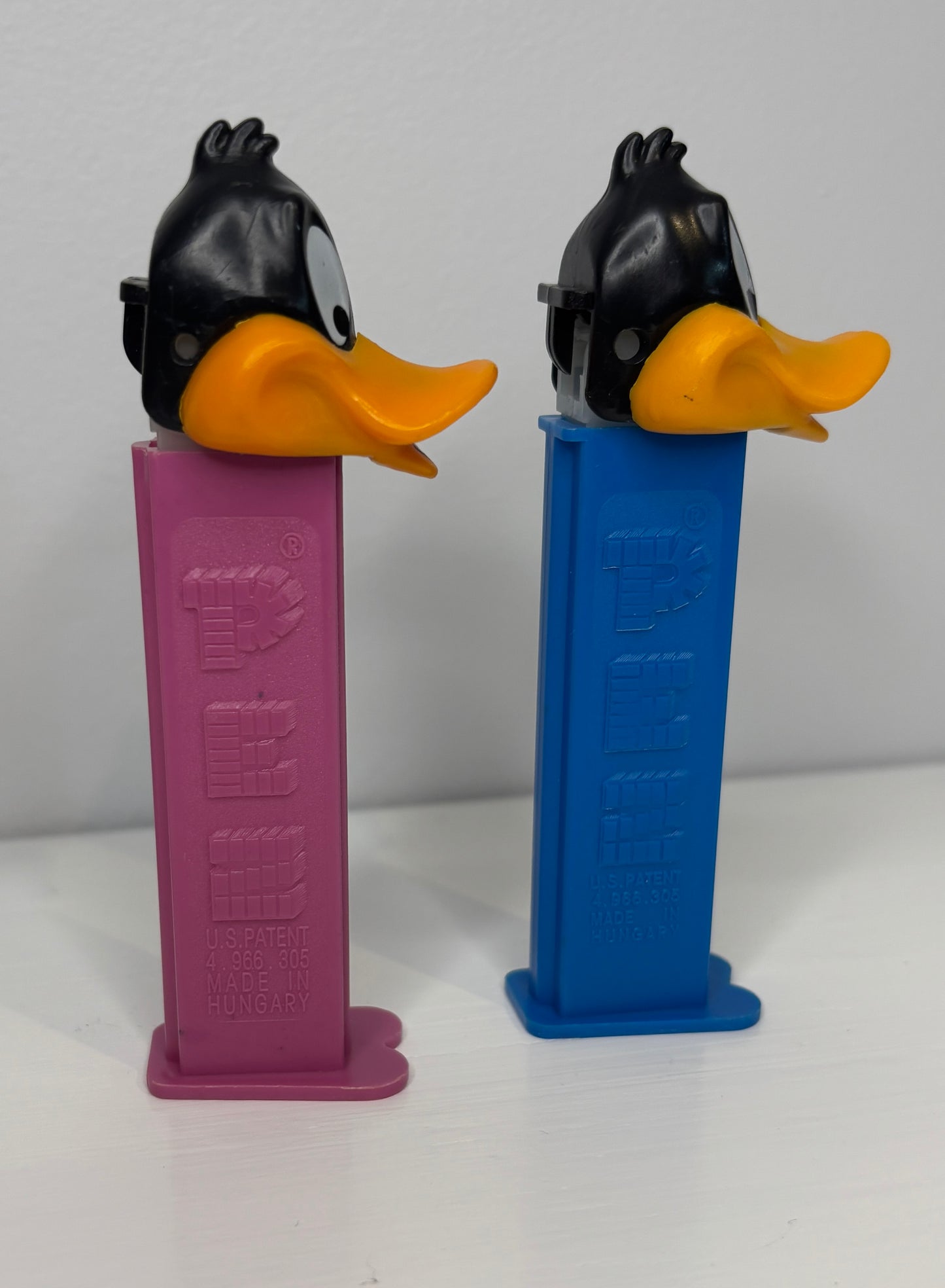 Two Pez dispensers shaped like cartoon characters on a white background