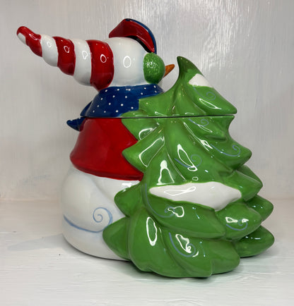 Christmas-themed cookie jar with elf design and green tree-shaped cookie jar on a white background