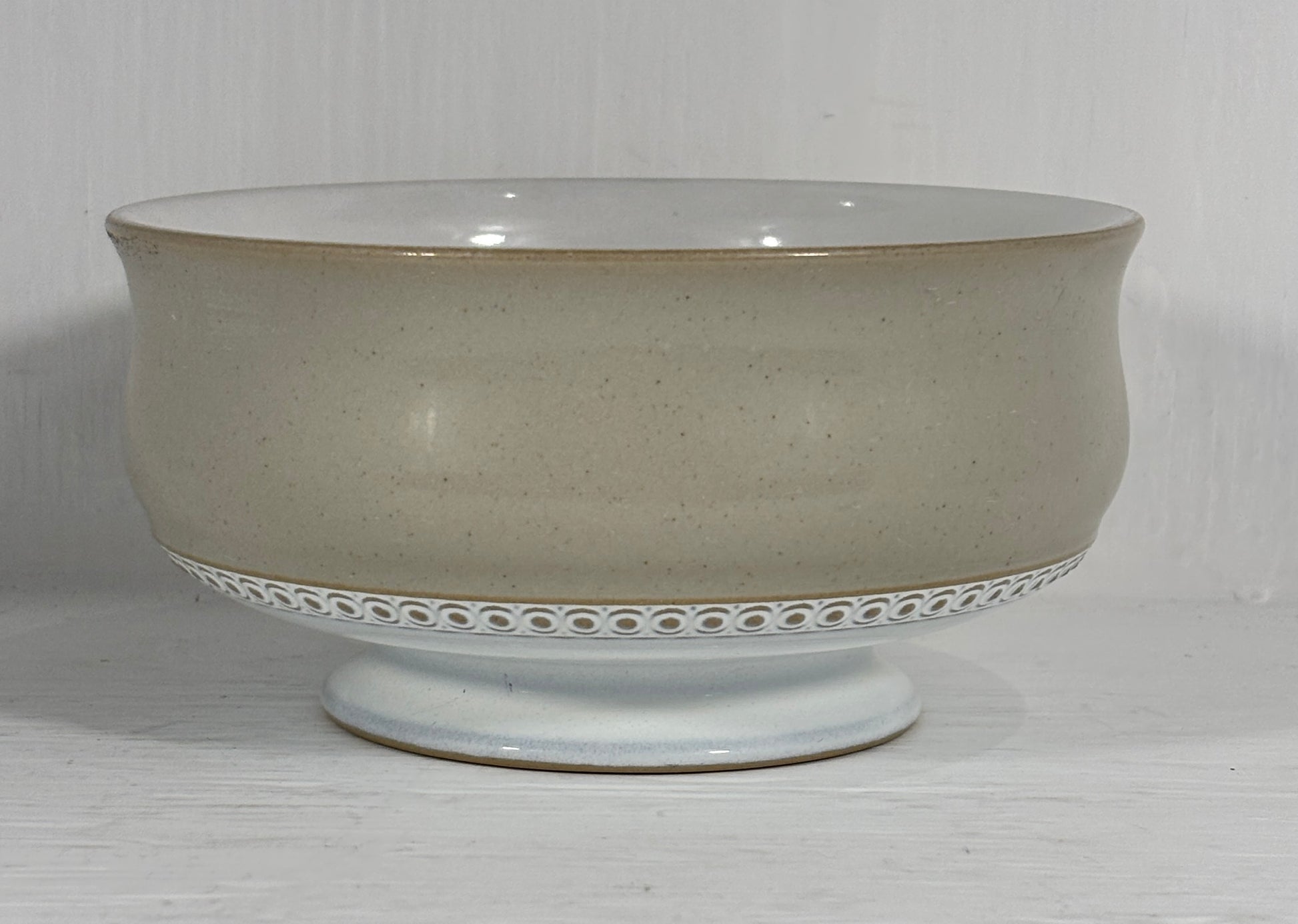 beige Ceramic bowl with decorative base on a white background