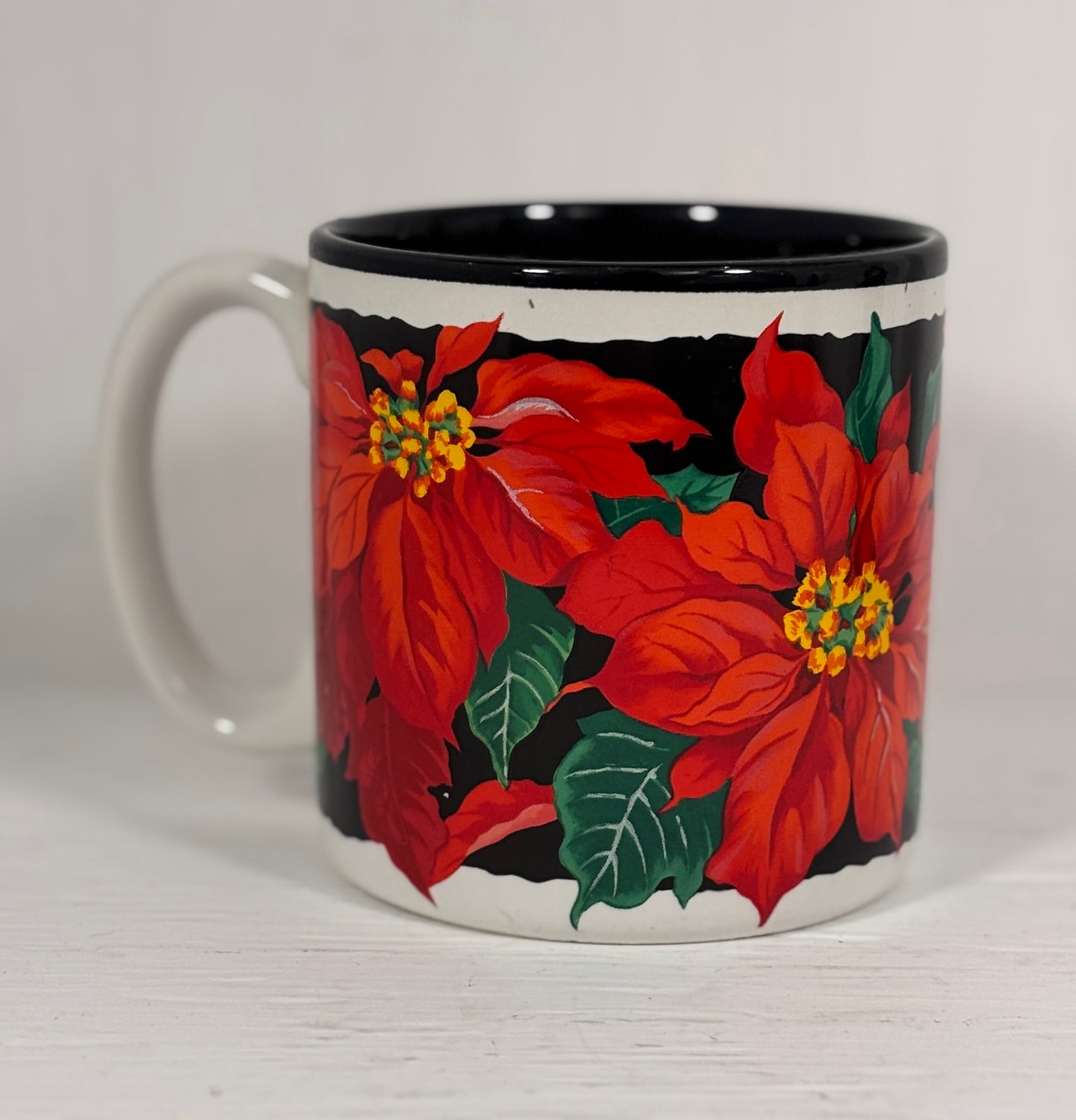 Mug with red poinsettia flowers on a white background