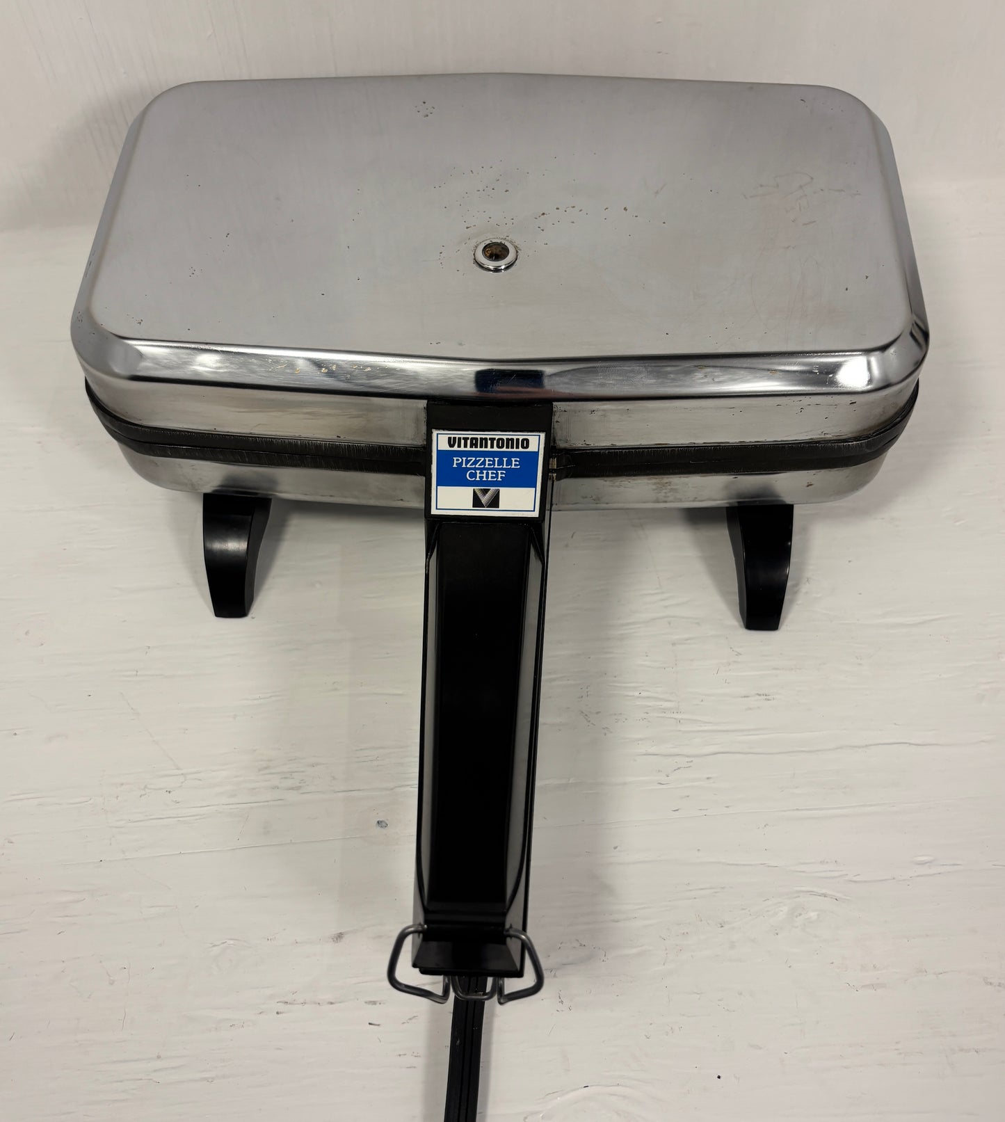 Stainless steel Italian cookie maker on a white background