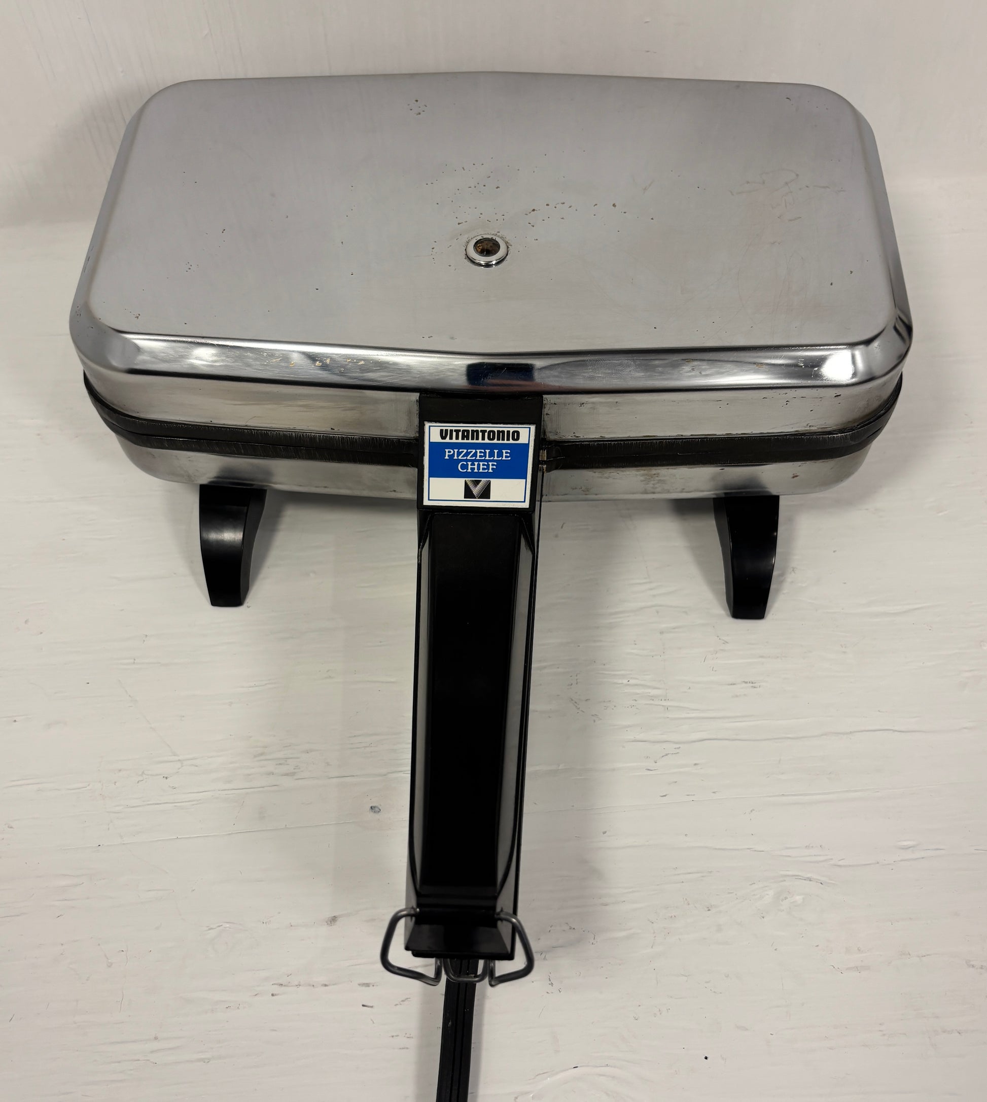 Stainless steel Italian cookie maker on a white background