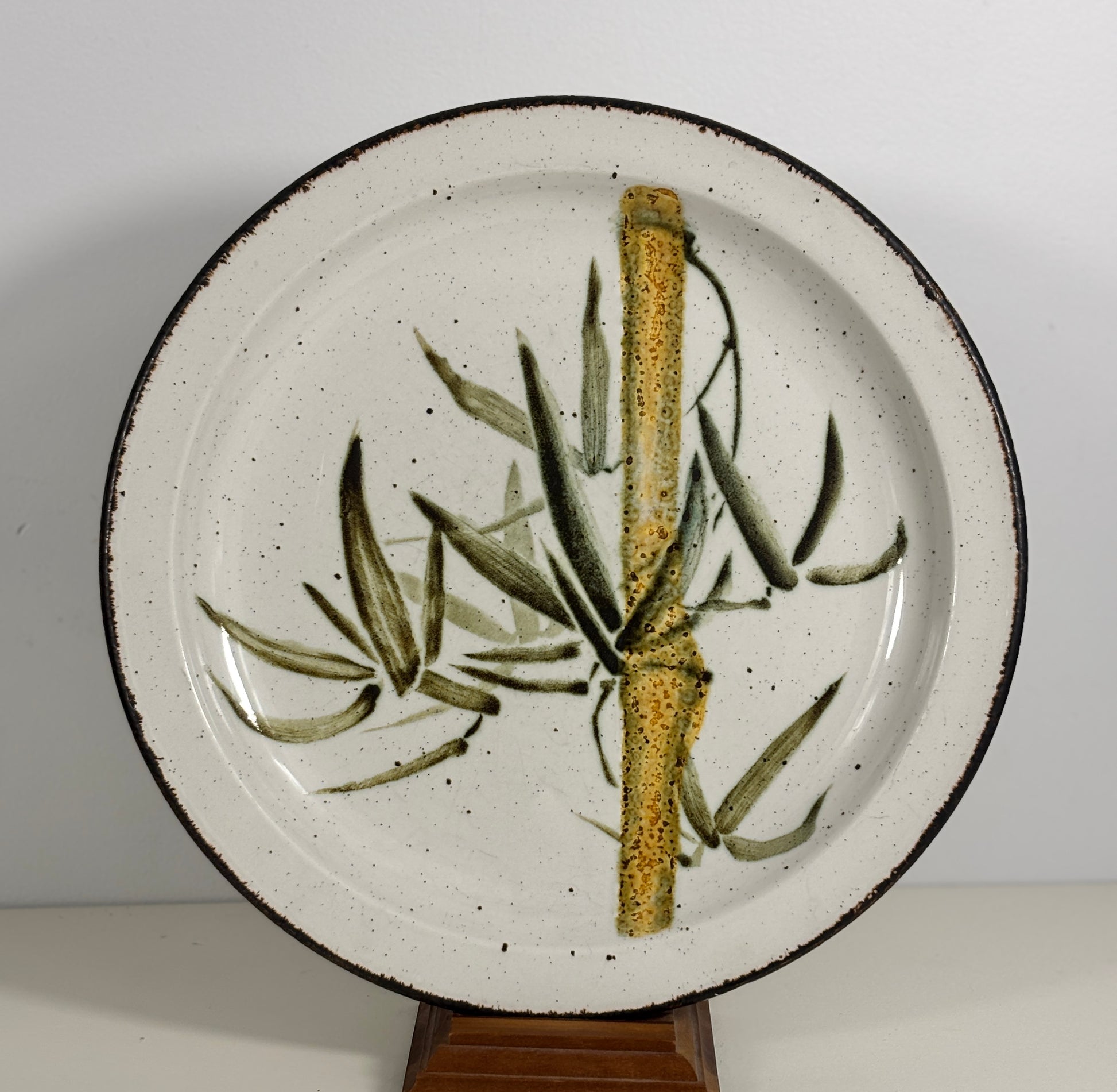 Ceramic plate with a design of a branch and leaves on a white background