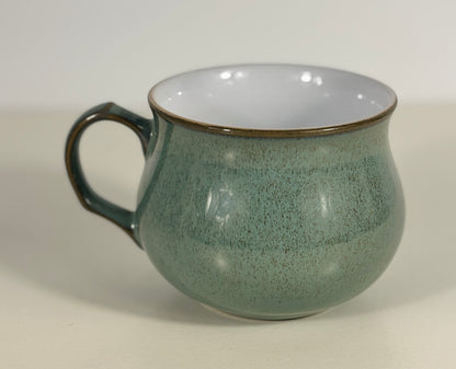 Green mug with a speckled texture on a light gray background