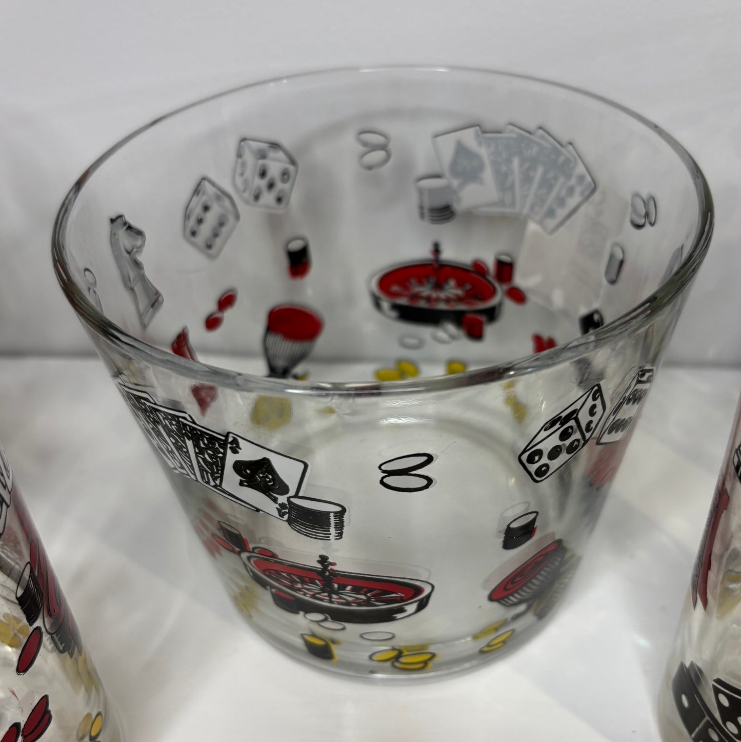Clear glass tumbler with poker-themed illustrations on a white background
