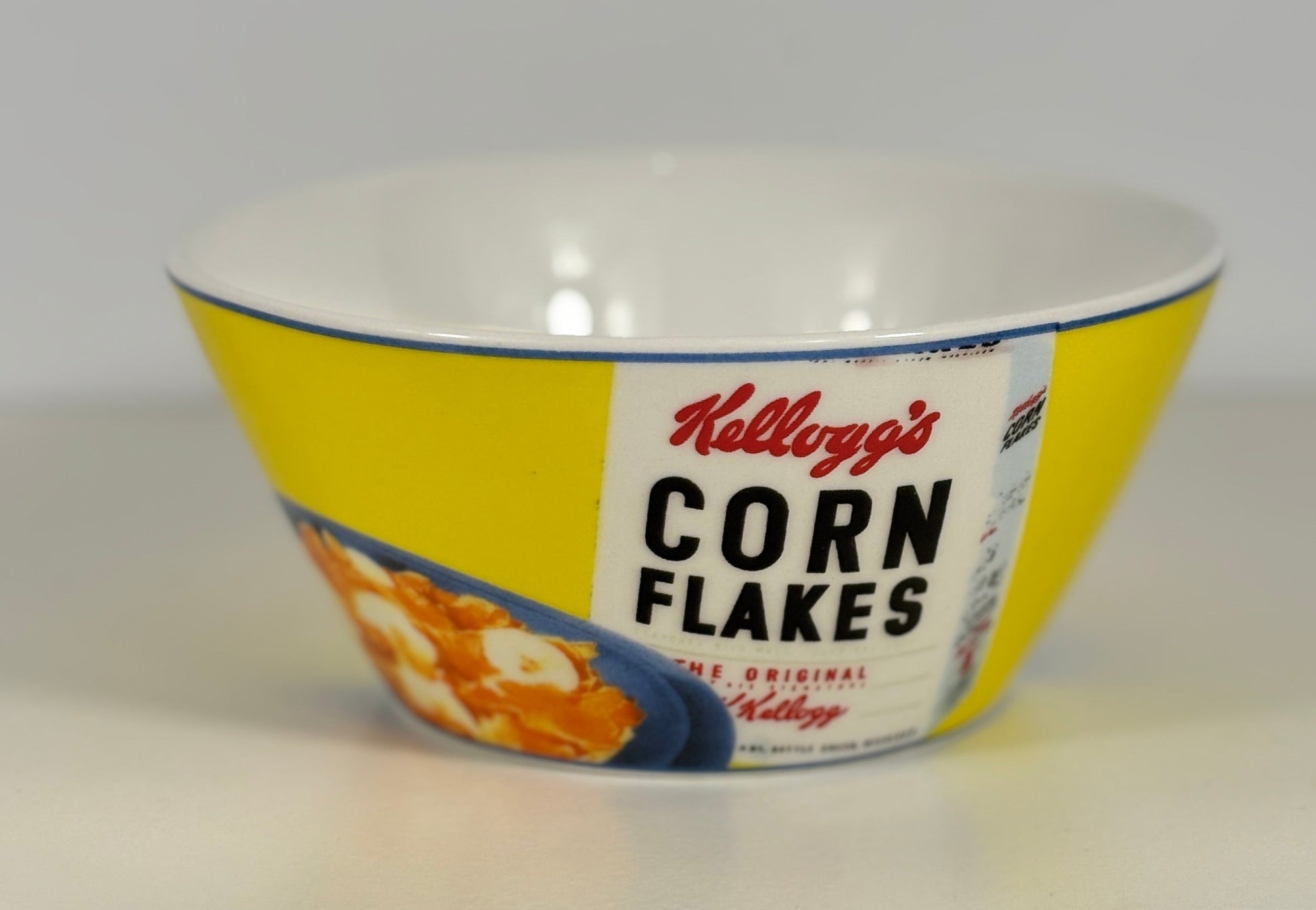 Vintage Kellogg's Corn Flakes bowl with yellow and white design on a white background