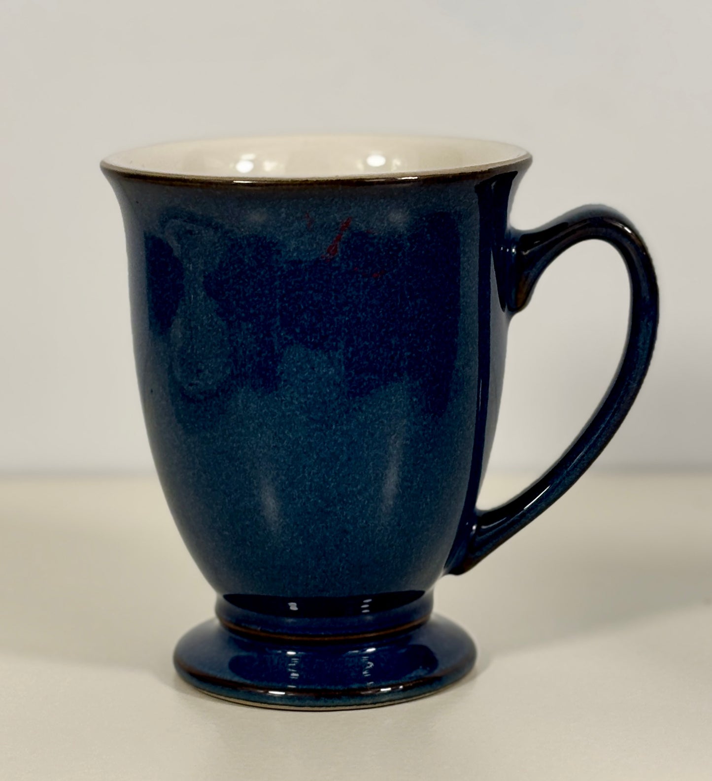 Blue mug with a white interior on a light gray background