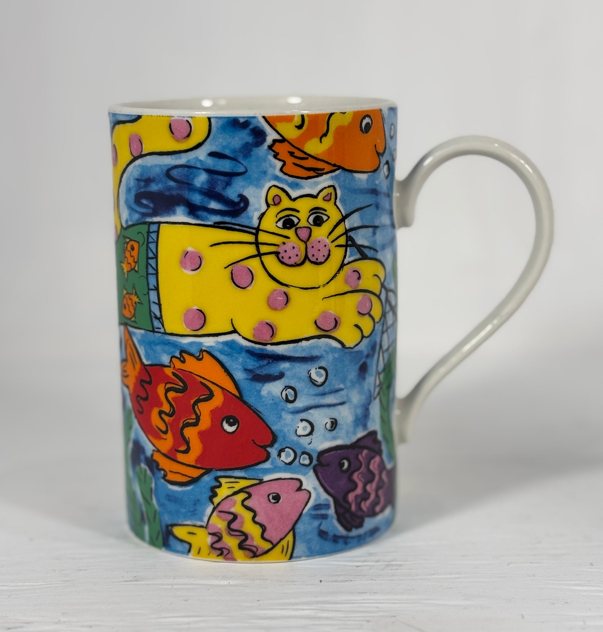 Colorful mug with a cat and fish design on a white background