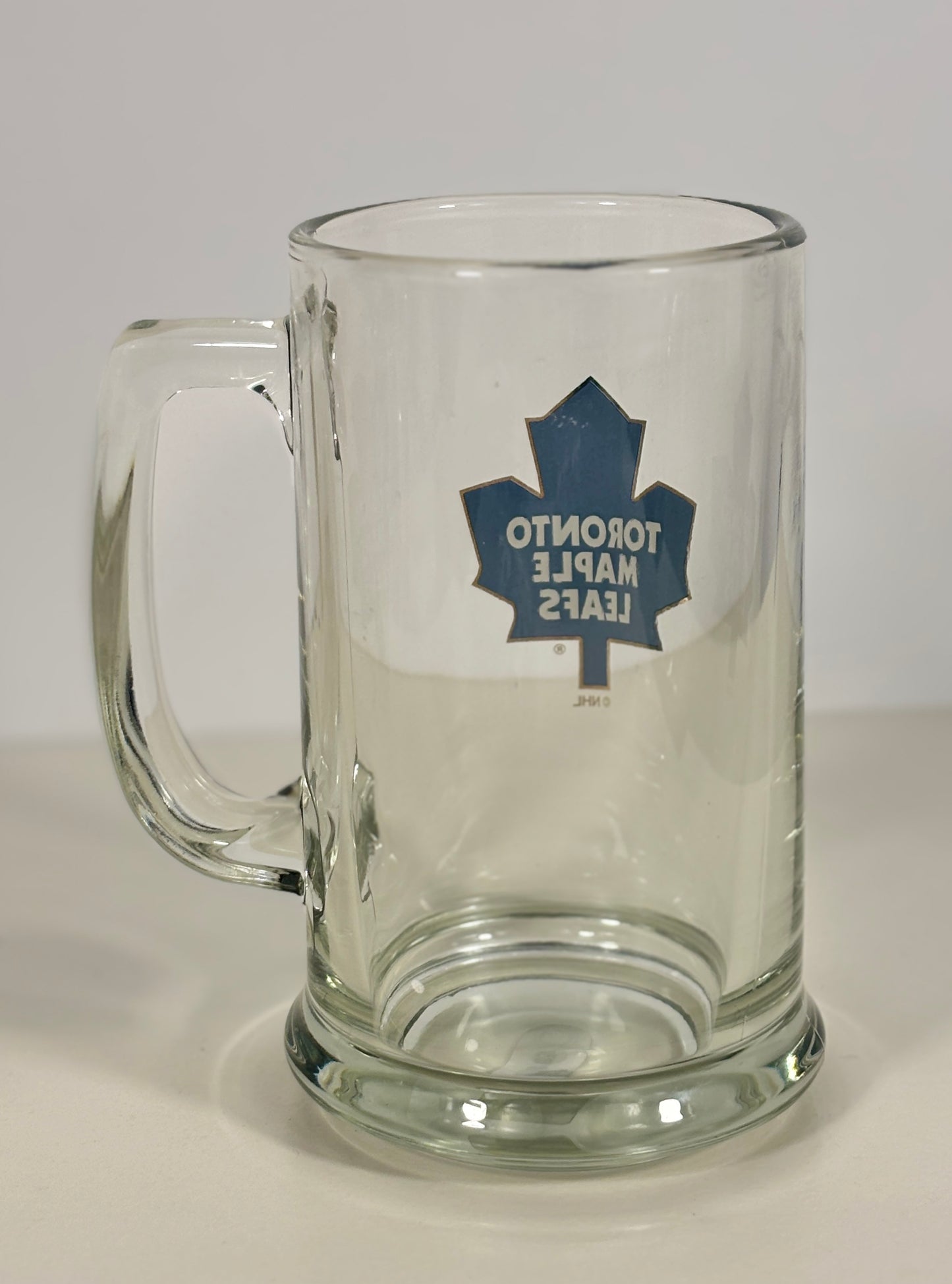 Clear glass mug with Toronto Maple Leafs logo on a white background