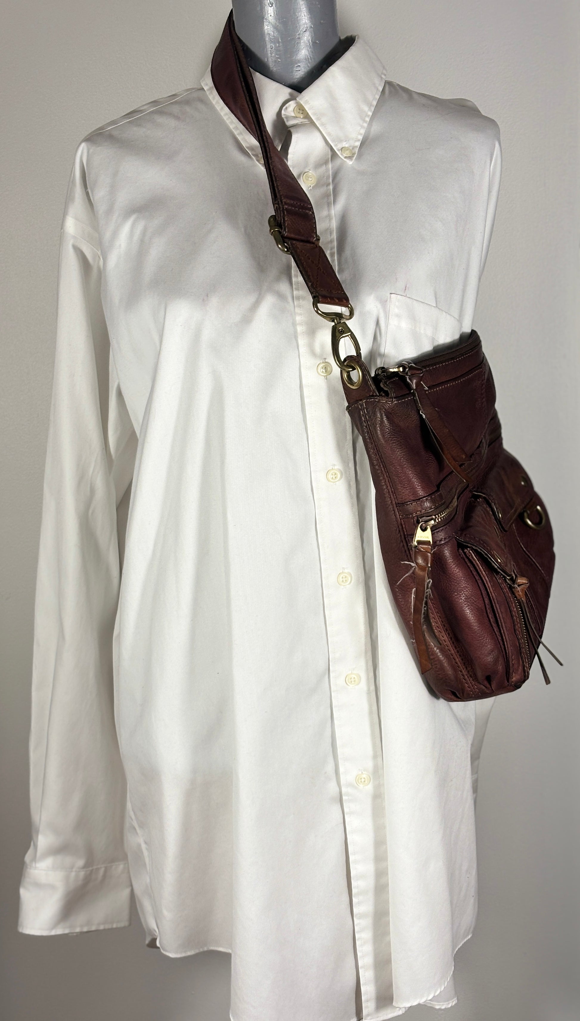 White shirt on a mannequin with a brown leather bag