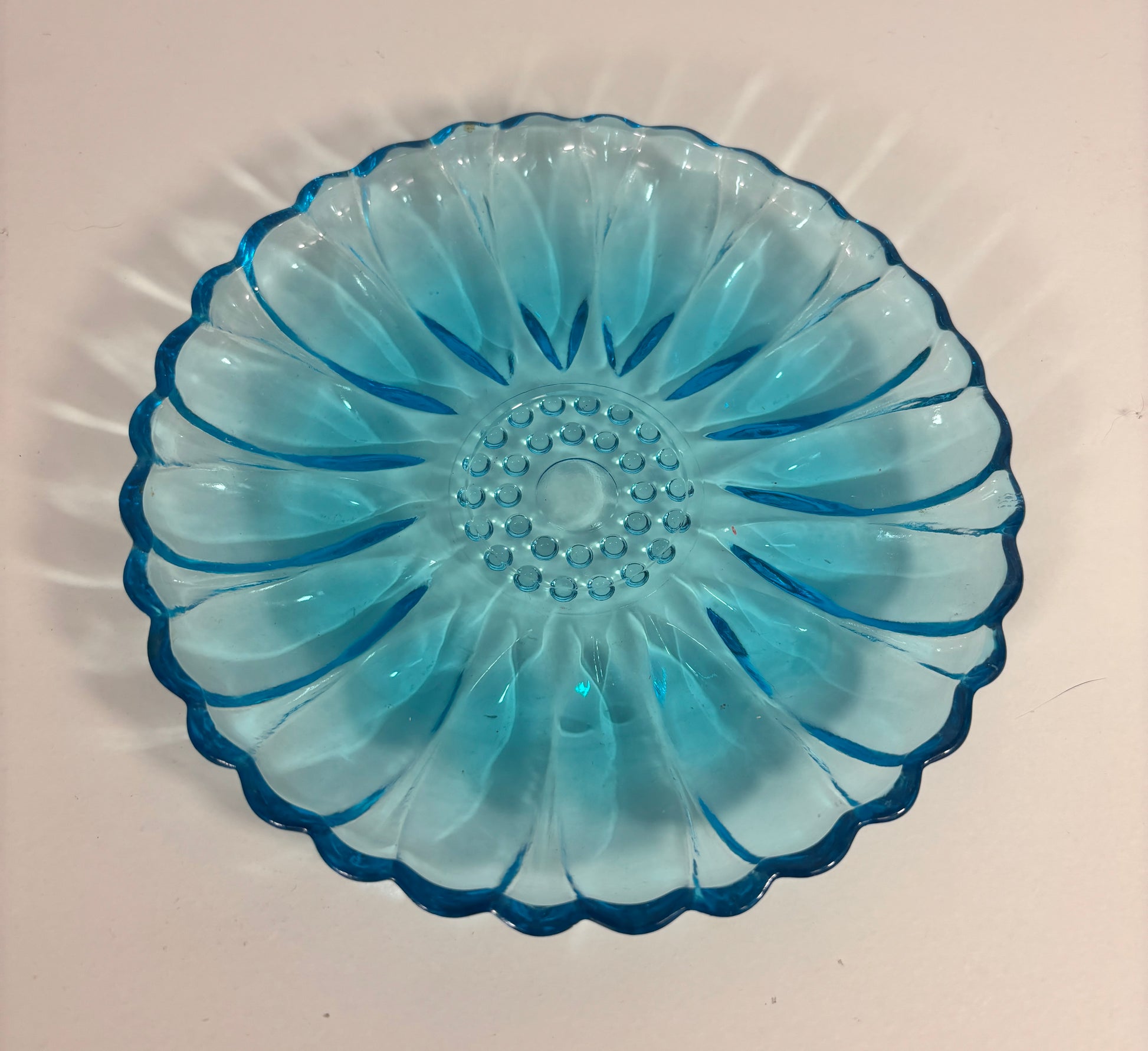 Blue glass dish with decorative pattern on a white background