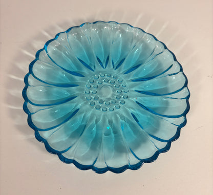 Blue glass dish with decorative pattern on a white background
