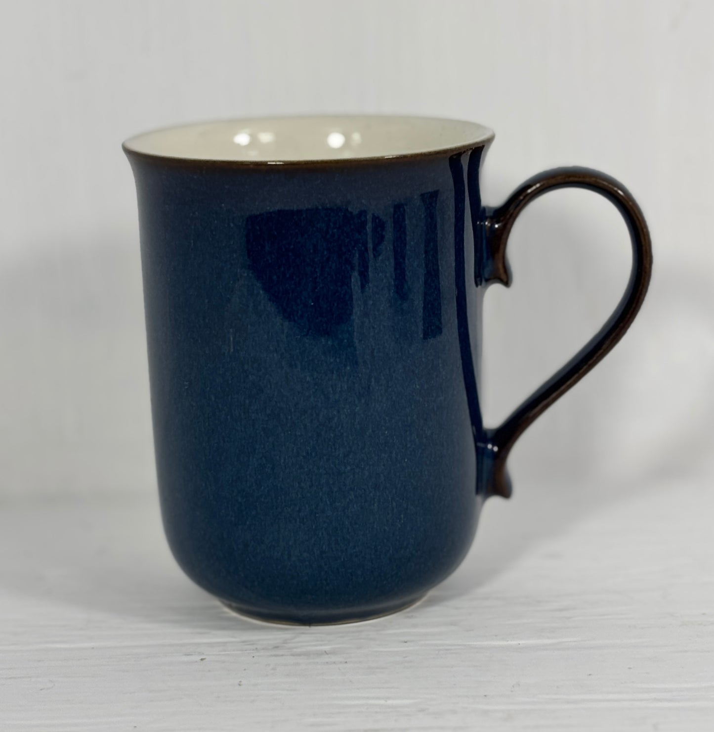 Blue mug with a white interior on a light gray background