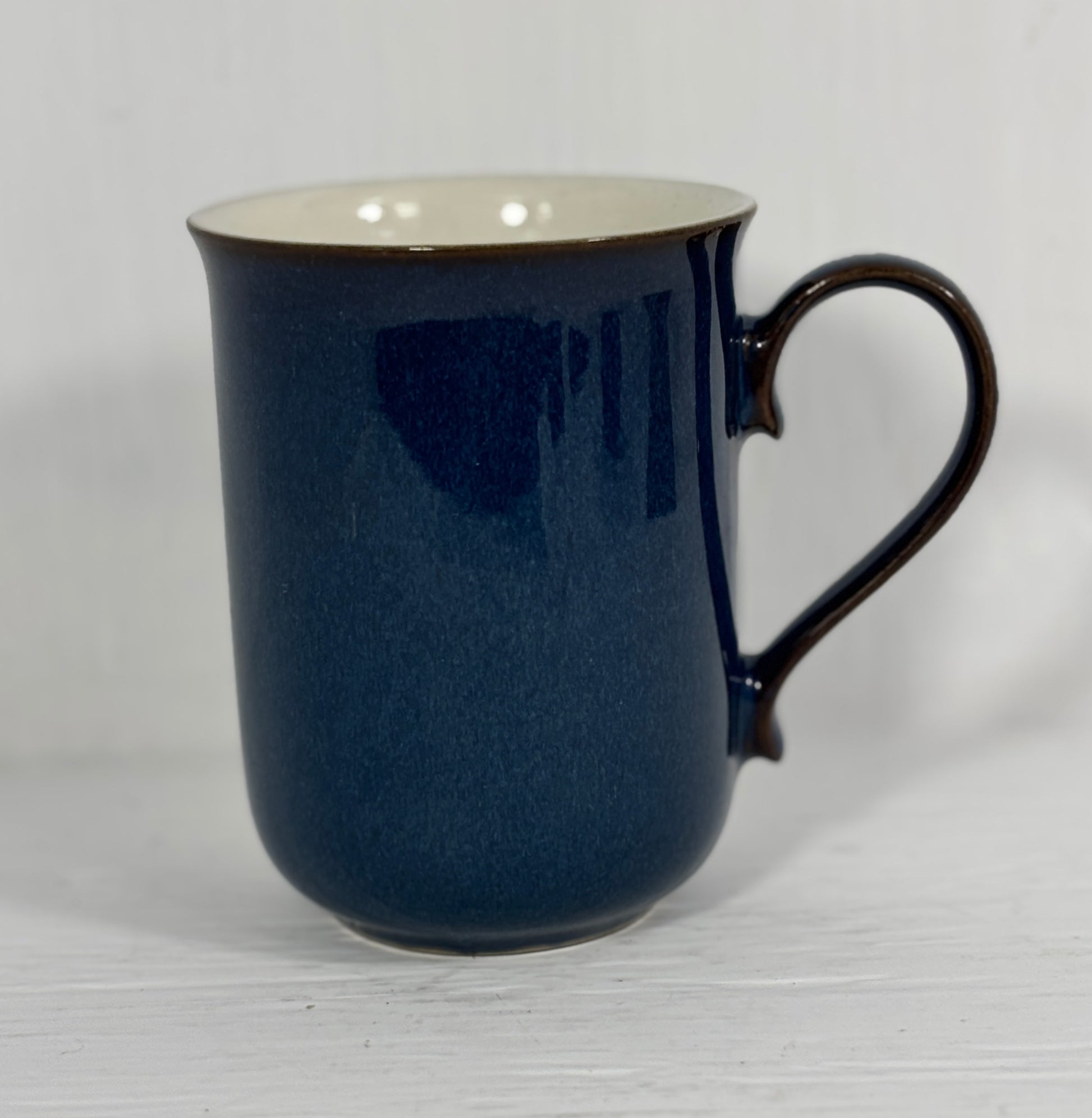 Blue mug with a white interior on a light gray background