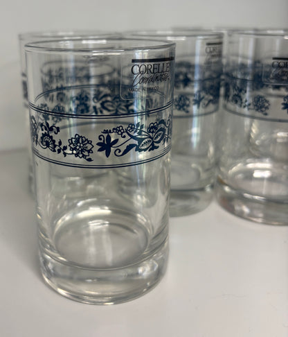 Clear glasses with blue floral patterns and Corelle branding on a white background