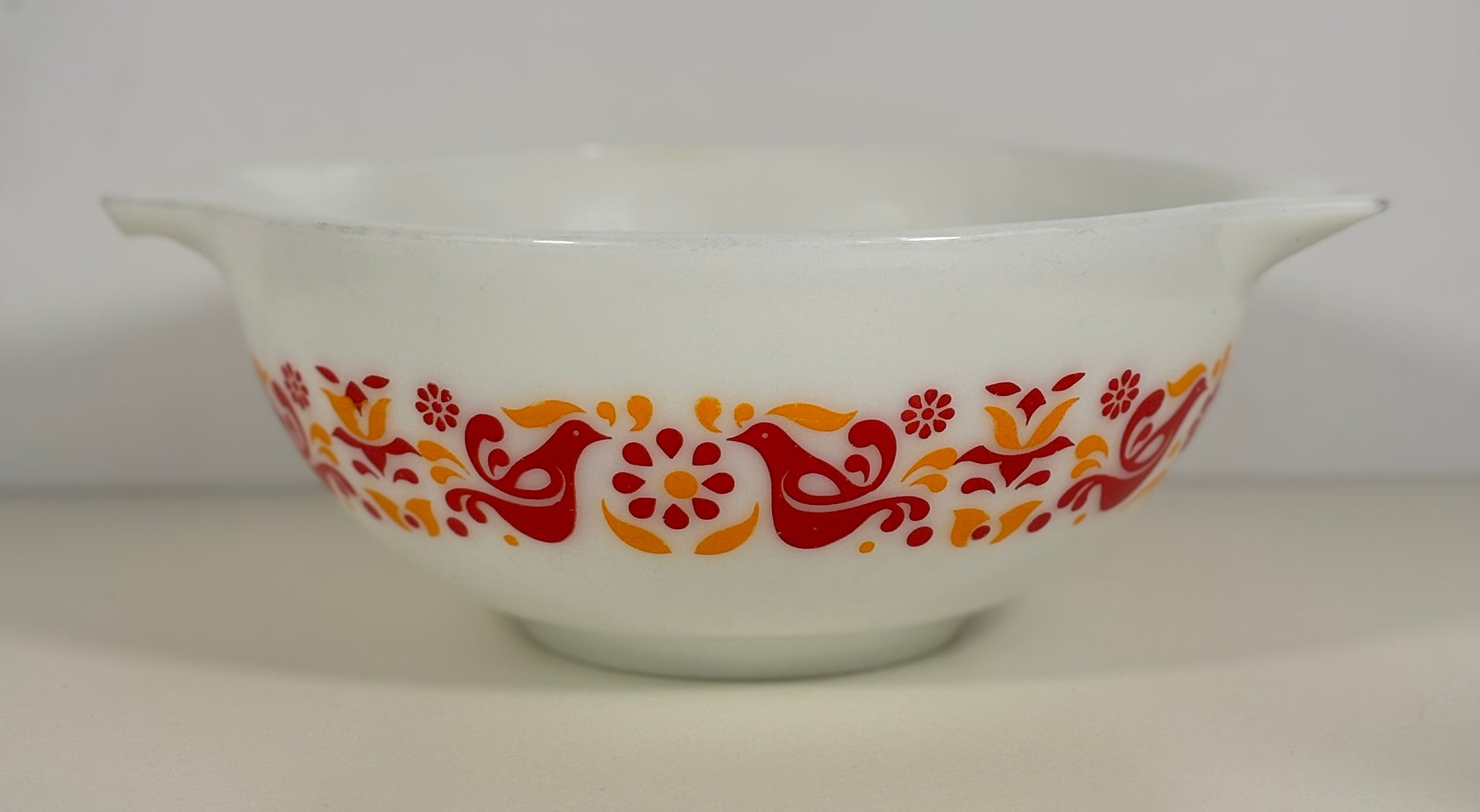 White bowl with red and orange floral pattern on a white background
