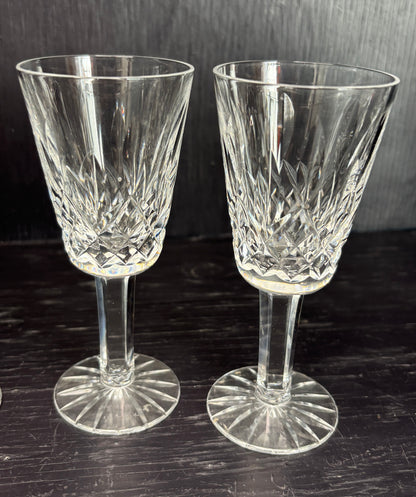 Two crystal sherry glasses on a dark surface