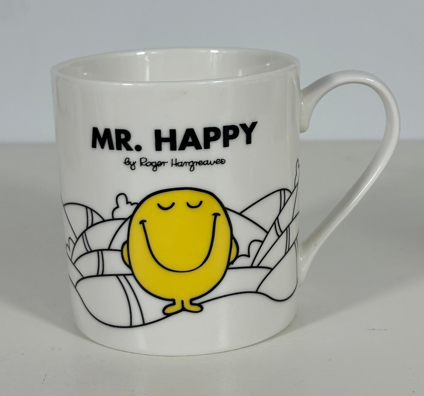 White mug with yellow character and 'Mr. Happy' text on a white background