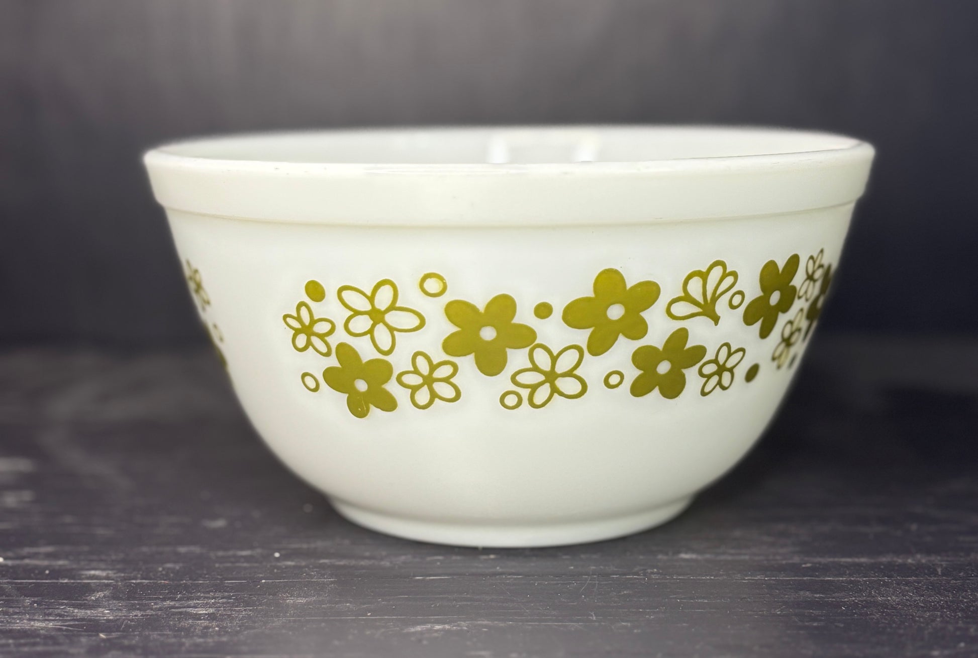 White bowl with gold floral pattern on a dark surface