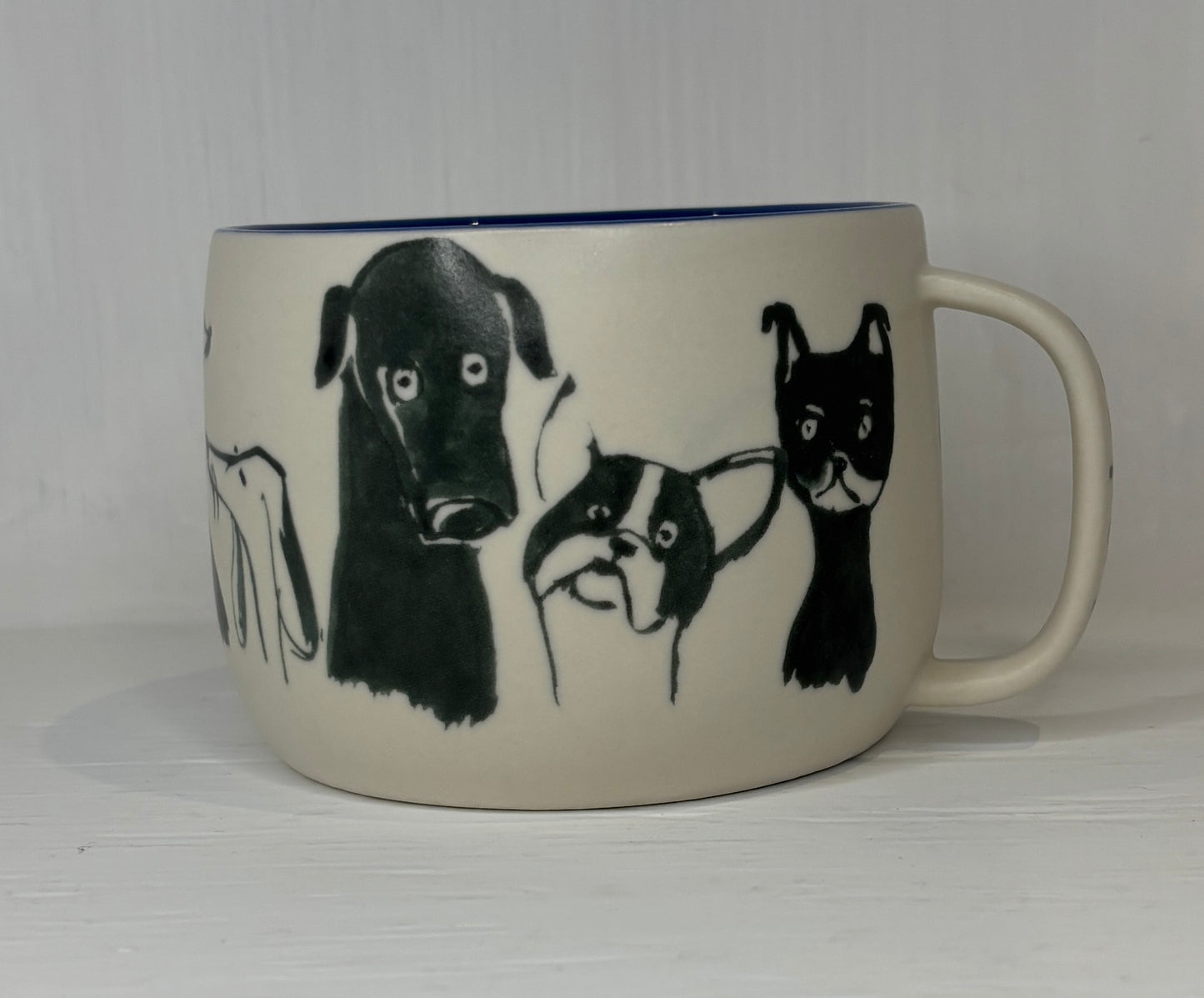 White mug with black illustrations of dogs on a white background