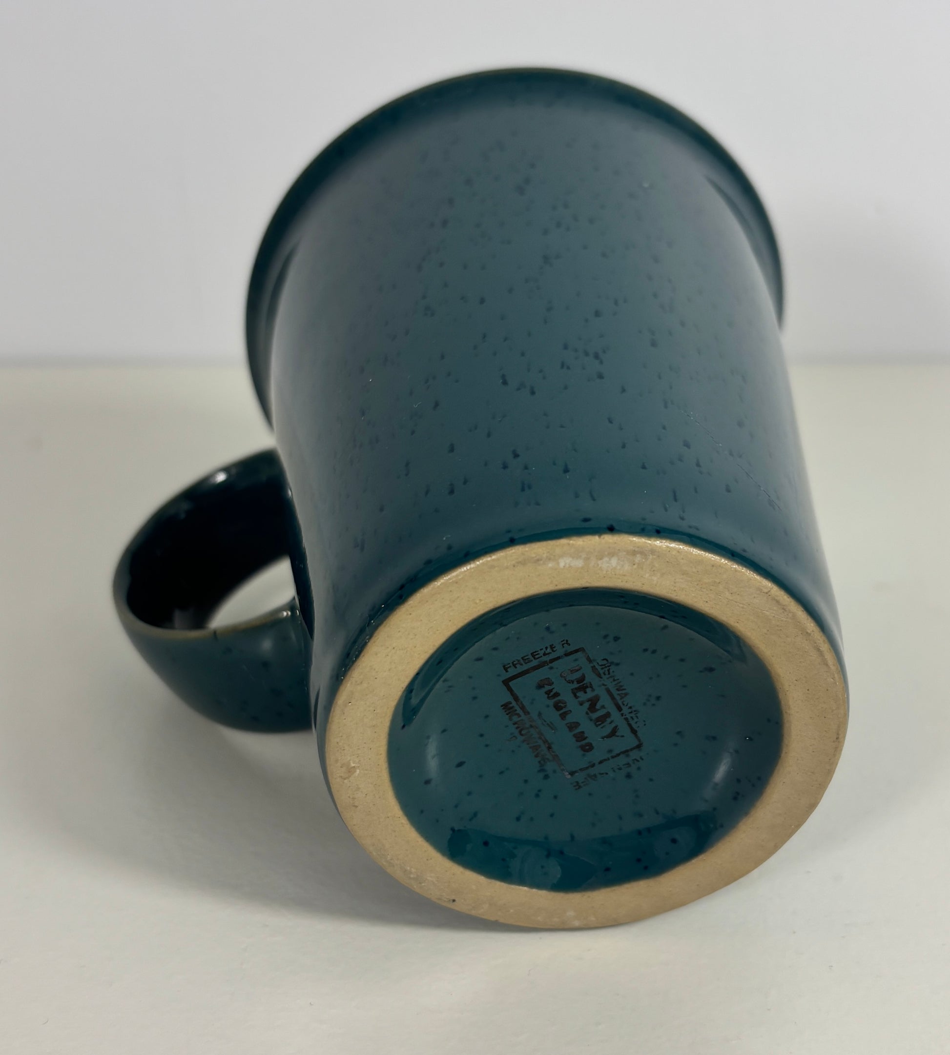 Blue ceramic mug with speckled texture on a white background
