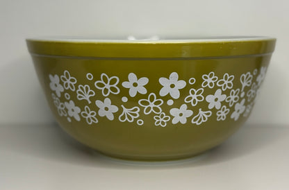 Green bowl with white floral pattern on a white background