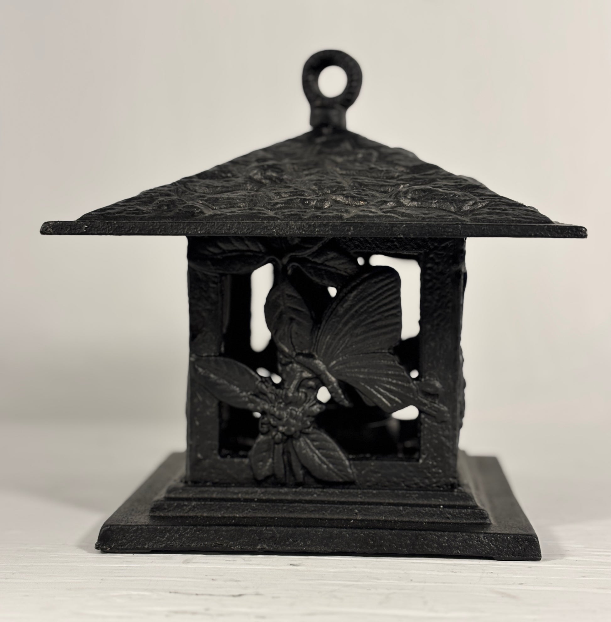 Black decorative lantern with floral designs on a white background