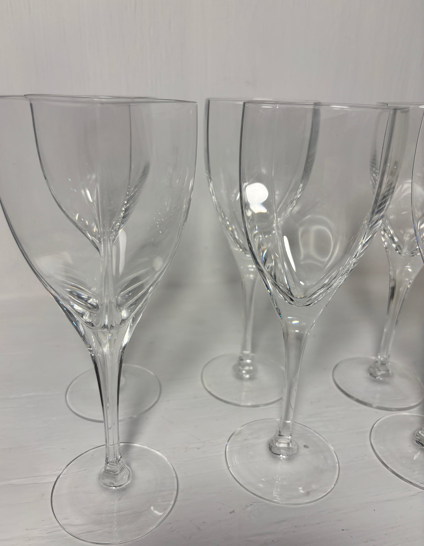 Set of clear wine glasses on a light gray surface