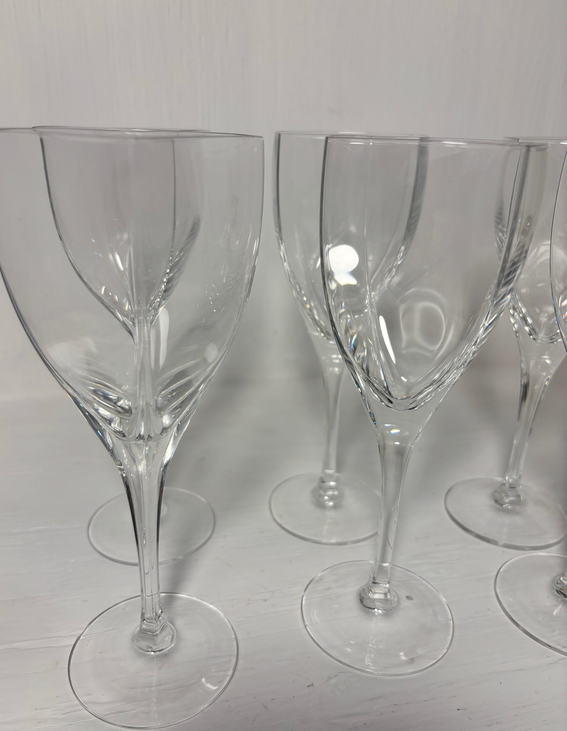 Set of clear wine glasses on a light gray surface