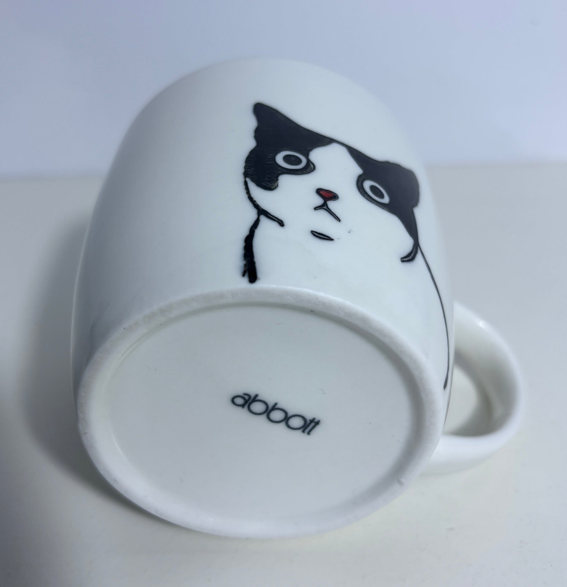 White mug with a black and white cat illustration on a white background
