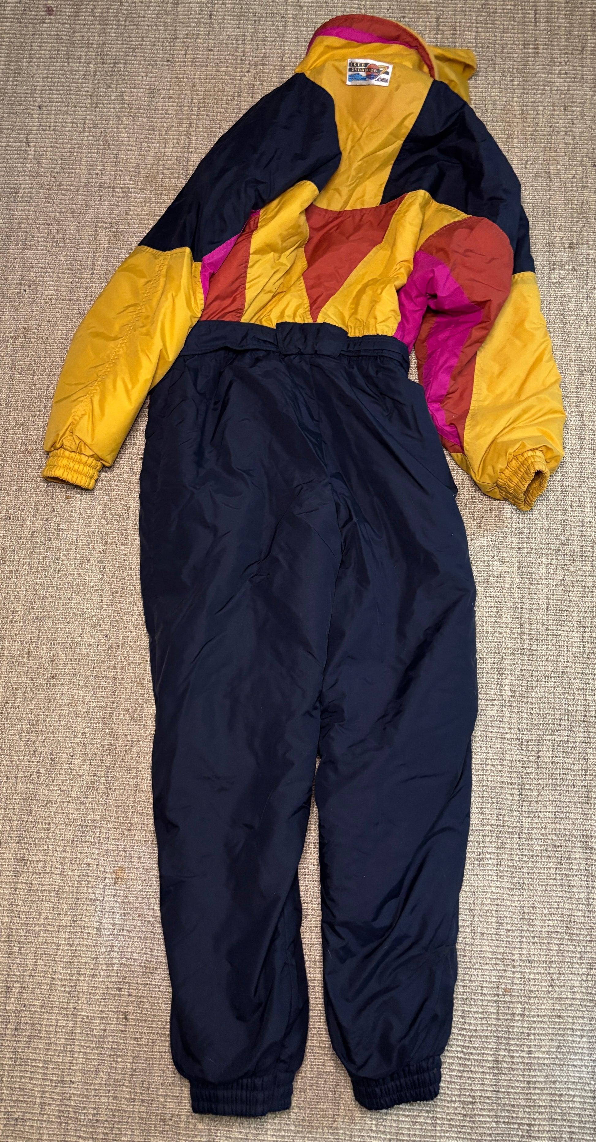 Colorful snowsuit with a jacket and pants on a textured surface
